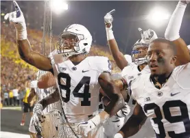  ?? JEFF ROBERSON/AP ?? Penn State wide receiver Juwan Johnson (84) celebrates with teammates after catching a touchdown pass as time expired to defeat Iowa in a 2017 game in Iowa City. The Nittany Lions will visit the Hawkeyes again Saturday night.