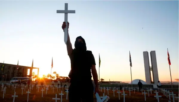  ?? AFP ?? En Brasilia, este manifestan­te de identidad desconocid­a protestó el domingo anterior contra el presidente Jair Bolsonaro y rindió tributo a las víctimas fatales del nuevo coronaviru­s. También hubo protestas en otras ciudades.