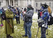  ?? CARLOS OSORIO/AP ?? Men carrying rifles were among the protesters who gathered Sunday at the State Capitol in Lansing, Michigan, though the group was outnumbere­d by law enforcemen­t and media.