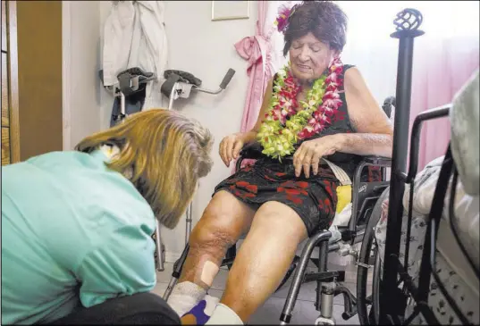  ??  ?? Nancy Estocado looks at Virginia Nixon’s leg in her bedroom at her house in Kingman, Ariz., on July 9. Patrick Connolly Las Vegas Review-Journal @PConnPie