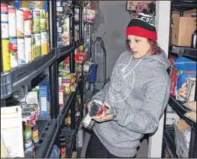  ?? FRAM DINSHAW/ TRURO NEWS ?? Recently emerging from homelessne­ss, Ali Archibald appreciate­s the chance to volunteer with the Truro Homeless Outreach Society. Christmas has been busy for her, as she stacks up donated food and household supplies on shelves in the basement.