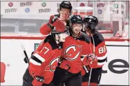  ?? Elsa / Getty Images ?? The Devils’ Egor Sharangovi­ch (17) is congratula­ted by teammates after he scored the winning goal in overtime against the Bruins on Saturday.