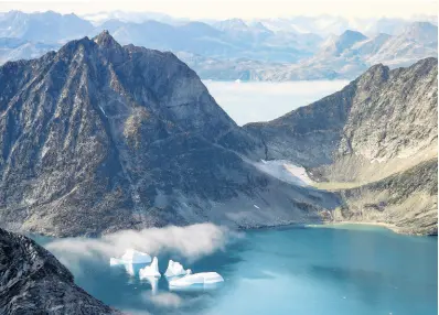  ?? AP ?? In this photo taken on Wednesday, icebergs are photograph­ed from the window of an airplane carrying NASA scientists as they fly on a mission to track melting ice in eastern Greenland.