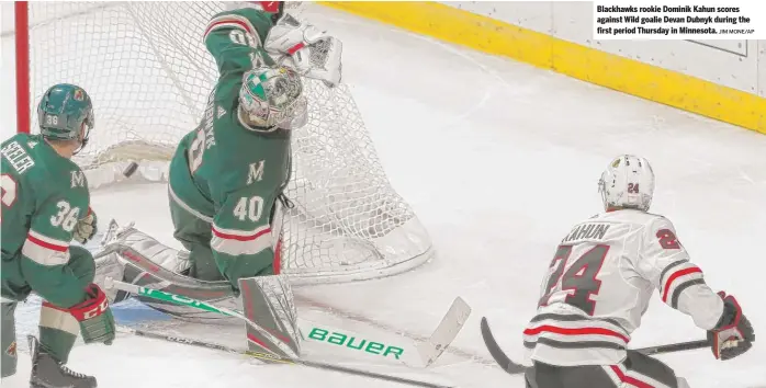  ?? JIM MONE/AP ?? Blackhawks rookie Dominik Kahun scores against Wild goalie Devan Dubnyk during the first period Thursday in Minnesota.