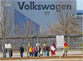  ?? STAFF PHOTO BY OLIVIA ROSS ?? On Dec. 18, a group of UAW supporters walks away from the Volkswagen plant carrying signs at the Volkswagen Chattanoog­a plant during a rally.