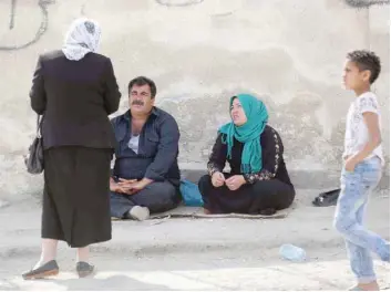  ?? — AFP ?? Relatives of Syrians they believe were kidnapped by Jaish fighters wait on the government-held side of the Wafideen checkpoint on the outskirts of Damascus on Monday.