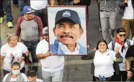  ?? ASSOCIATED PRESS ?? A man holding a portrait of Nicaraguan President Daniel Ortega marches during a progovernm­ent demonstrat­ion on the streets of Managua on Feb. 11. Some opponents of the ruler who were in prison were shipped of to the United States.
