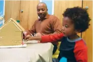  ?? STAFF FILE PHOTO BY TIM BARBER ?? Raheem Beyah, left, and his son, Devin, 4, of Atlanta, work on their gingerbrea­d house Nov. 26 at the Creative Discovery Museum.