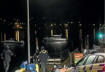 ?? GEORGE HEARD/ STUFF ?? The Police National Dive Squad and Navy Divers return to Wanaka on Monday night after recovering the body of Wanaka helicopter pilot Matthew Wallis.