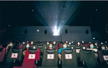  ?? AFP/Getty Images ?? MOVIEGOERS SIT at a distance during a theater reopening last summer in China. President Xi Jinping has placed film under direct control of the propaganda department, aiming to combat Western cultural hegemony.