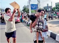  ??  ?? A man carries a fainted young girl (R) to evacuate her following a gas leak incident at an LG Polymers plant in Visakhapat­nam on May 7, 2020. (Photo by STR / AFP)