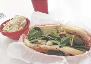 ?? PHOTO BY BEN BENTON ?? A grilled chicken melt made with grilled chicken, roasted red peppers, mushrooms and baby spinach topped with melted Parmesan and provolone cheeses comes on a grilled hoagie roll with a side of house potato salad.