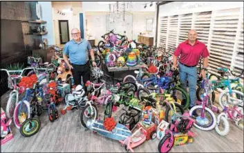  ?? Tri Pointe Homes ?? Chet Buchanan, left, the KLUC-FM, 98.5, DJ whose annual toy drive to benefit HELP of Southern Nevada is now in its 23rd year, and Klif Andrews, Division President for Tri Pointe Homes, pose with bicycles and toys already collected for the drive.