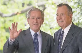  ?? JIM WATSON/AFP/GETTY IMAGES ?? Then-President George W. Bush walks out of the Oval Office with his father, former President George H.W. Bush, on Sept. 25, 2008.