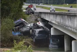  ?? JOHN AMIS — THE ASSOCIATED PRESS ?? Cars are stacked on top of each other on the banks of Blue Creek being swept up in flood water, Monday in Waverly, Tenn. Heavy rains caused flooding in Middle Tennessee days ago and have resulted in multiple deaths as homes and rural roads were washed away.