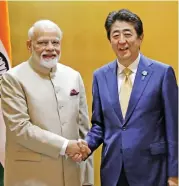  ?? (Bloomberg) ?? India’s Prime Minister Narendra Modi (left) shakes hands with his Japanese counterpar­t Shinzo Abe in Osaka, Japan on June 27