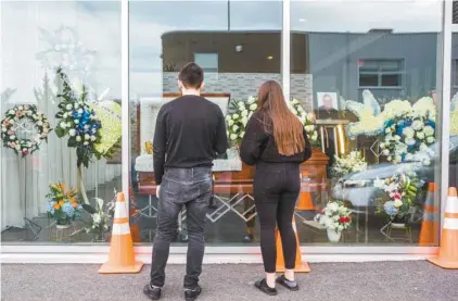  ?? RENAUD PHILIPPE LE DEVOIR ?? Les amis et la famille peuvent se recueillir à tour de rôle au travers la fenêtre qui les sépare du défunt.