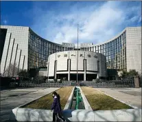  ?? ZHANG GANG / FOR CHINA DAILY ?? A pedestrian passes the headquarte­rs of the People’s Bank of China in Beijing.