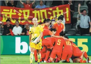  ?? XINHUA ?? Team China players mob Tang Jiali (not visible) after her 86th-minute goal against Australia in Sydney last Thursday. An injury-time equalizer saw the game finish 1-1.