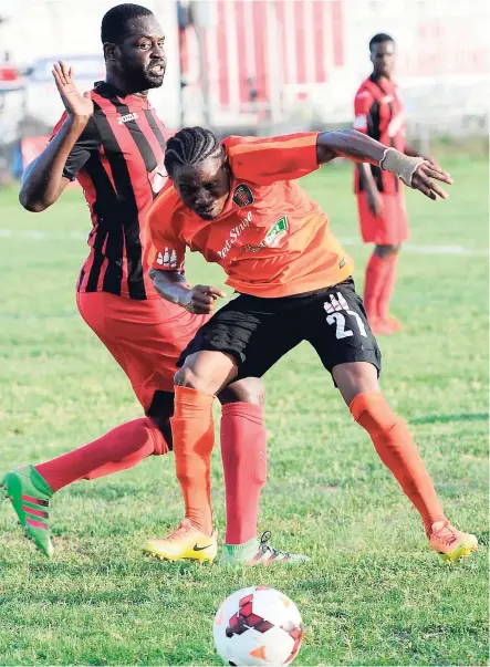  ??  ?? Tivoli Gardens’ Elton Thompson (right) takes evasive action while Arnett Gardens player Oneil Thompson attempts to make a tackle in their Red Stripe Premier League encounter at the Edward Seaga Sports Complex on December 4. Tivoli won the game 3-2.