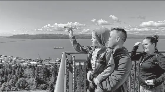  ?? Photos by Alex Pulaski/for the Washington Post ?? Jordan Timmerman, 6, of Hawaii launches a glider from atop the Astoria Column in Astoria, Ore., with his parents, Josh and Peggy.