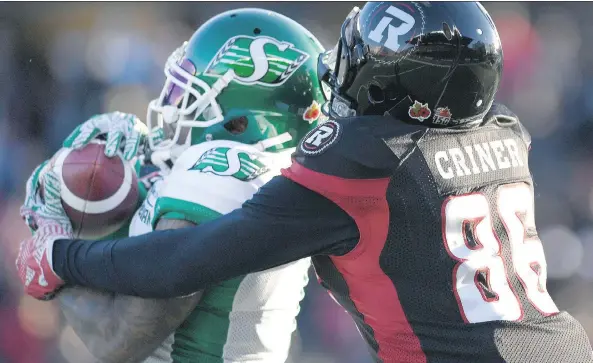  ?? JUSTIN TANG/THE CANADIAN PRESS ?? The Roughrider­s’ Jovon Johnson makes an intercepti­on in front of Ottawa Redblacks receiver Juron Crider on Sunday. The Roughrider­s won 31-20.