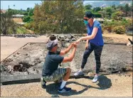  ?? AP PHOTO BY MIKE ELIASON, SANTA BARBARA COUNTY FD ?? Ishu Rao, on one knee, places this wife's wedding ring on her finger, next to the charred remains of their home in Goleta, Sunday, July 8.