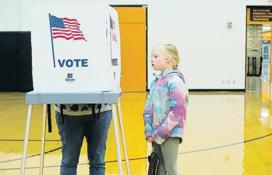  ?? ?? Una nena observant la seva mare mentre vota en una institut públic de secundària a Sioux City (Iowa) dimarts