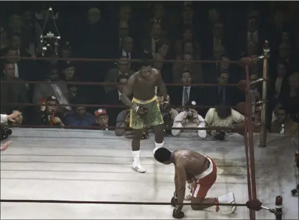  ?? UNCREDITED - STAFF, AP ?? Boxer Muhammad Ali looks up towards Joe Frazier, center, during a title fight at Madison Square Garden in New York, in this March 8, 1971, file photo.