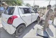  ??  ?? Police inspect the car used by the robbers on Sunday. ARUN SHARMA / HT