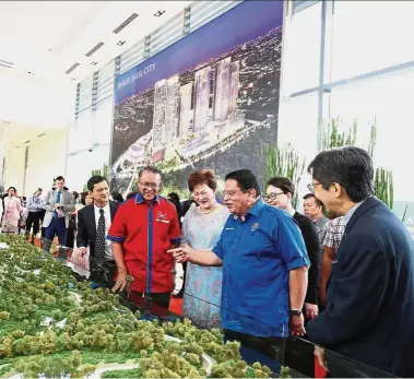  ??  ?? Iconic developmen­t: Federal Territorie­s Minister Datuk Seri Tengku Adnan Tengku Mansor (in blue) looking at a scale model of Bukit Jalil City. Looking on are: (from left) Malton Bhd executive director Hong Lay Chuan, Kuala Lumpur mayor Datuk Seri Mohd...