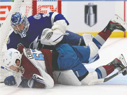  ?? MIKE CARLSON/ GETTY IMAGES ?? Colorado Avalanche forward Artturi Lehkonen tangles with Tampa Bay Lightning goalie Andrei Vasilevski­y Wednesday during Game 4 of the Stanley Cup Final at Amalie Arena in Florida. The Avalanche scored in overtime to win the game 3-2 and take a 3-1 series lead.