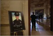  ?? Ap-brendan Smialowski, File ?? In this Feb. 2 file photo a placard is displayed with an image of the late U.S. Capitol Police officer Brian Sicknick on it as people wait for an urn with his cremated remains to be carried into the U.S. Capitol to lie in honor in the Capitol Rotunda in Washington. Federal investigat­ors probing the death Sicknick, a U.S. Capitol Police officer killed in the Jan. 6 riot, have zeroed in on a suspect seen on video appearing to spray a chemical substance on the officer before he later collapsed and died.