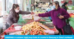  ??  ?? SHENYANG: A customer (right) buys fruits at a market in Shenyang in China’s northeaste­rn Liaoning province. — AFP