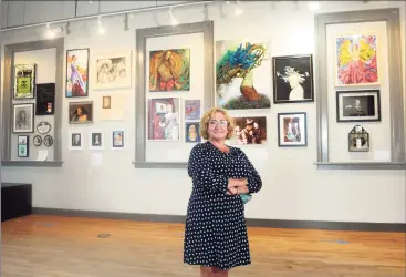  ?? Ned Gerard / Hearst Connecticu­t Media ?? Executive director Paige Miglio poses with part of the Story of Women exhibit currently on display at the Milford Arts Council.