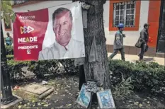  ?? Guillermo Arias / Getty Images ?? Men walk near a banner of a presidenti­al candidate, Jose Antonio Meade, on Saturday, a day before elections.