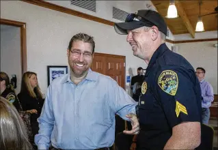  ?? DAMON HIGGINS / THE PALM BEACH POST ?? Brian Smith (left) shares a laugh Tuesday with Boynton Beach Police Sgt. Brian McDeavitt, who performed chest compressio­n on Smith after he suffered a heart attack while jogging. McDeavitt was honored by the department in a ceremony at Intracoast­al Park.