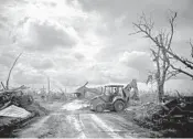  ?? RAMON ESPINOSA/AP ?? A bulldozer clears the road after Hurricane Dorian in McLean’s Town, Grand Bahama island.