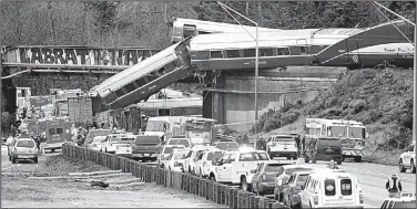  ?? AP/ELAINE THOMPSON ?? Rail cars from a wrecked Amtrak train are removed in December from a bridge over Interstate 5 near DuPont, Wash. The National Transporta­tion Safety Board released a report on the accident Thursday.