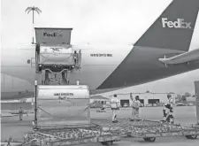  ?? COURTESY OF FEDEX ?? Fedex Express employees help load up a cargo jet with Johnson & Johnson COVID-19 vaccine doses at the Fedex Express World Hub in Memphis on March 1.