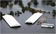  ?? AP PHOTO BY STEVE HELBER ?? Hog farm buildings are inundated with floodwater from Hurricane Florence near Trenton, N.C., Sunday, Sept. 16.