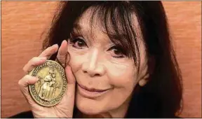  ??  ?? Juliette Gréco et sa médaille de citoyenne d’honneur de Montpellie­r, en 2012.