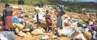  ?? Zinyange Auntony / AFP/Getty Images ?? Women dry clothes recovered from rubble on Tuesday in the Ngangu township of Chimaniman­i, after the area was hit by the Cyclone Idai. More than a thousand people are feared to have died in Mozambique alone while scores have been killed and more than 200 are missing in neighbouri­ng Zimbabwe following the deadliest cyclone to hit southern Africa.