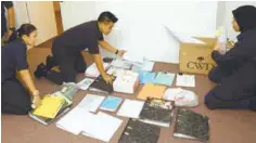  ??  ?? Enforcemen­t officers sifting through the files and documents seized during the raids.