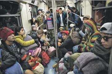  ?? Rodrigo Abd Associated Press ?? CENTRAL AMERICANS who are part of the main caravan walking north through Mexico ride a subway in the capital after leaving a temporary shelter at a stadium nearby, where 5,500 people have been camping.