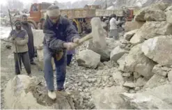  ?? — Reuters ?? A labourer uses a sledgehamm­er on a boulder at a stone quarry in Srinagar.