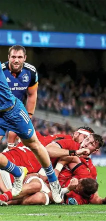  ?? ?? UNDER THE COSH: Munster’s Diarmuid Barron is swamped by Leinster tacklers; Joey Carbery leaves the fray injured, right