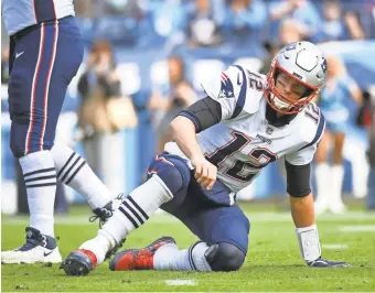  ?? CHRISTOPHE­R HANEWINCKE­L/ USA TODAY ?? Patriots quarterbac­k Tom Brady gets up off the field after slipping on a pass attempt during the first half against the Titans at Nissan Stadium.