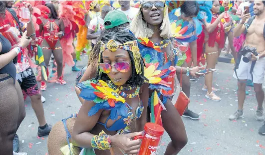  ?? FILE ?? Anita Baahmensah (left) from Ghana and Caroline Idi from Nigeria feting along the Xodus Jamaica Carnival route last year.