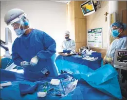  ?? Francine Orr Los Angeles Times ?? A CARDIAC TEAM works on a COVID- 19 patient at Providence Holy Cross Medical Center in L. A. The state has nearly 17,000 coronaviru­s hospitaliz­ations.